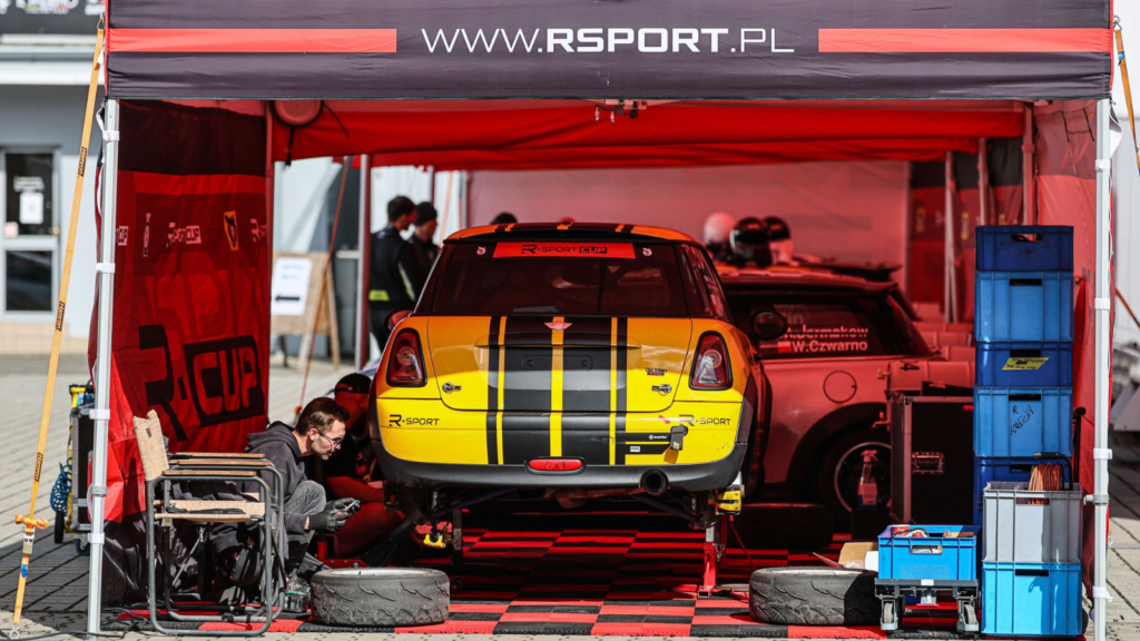 Mechanik R Sport serwisuje Mini Coopera R56 w padoku na Torze Poznań podczas rundy R Sport Cup
